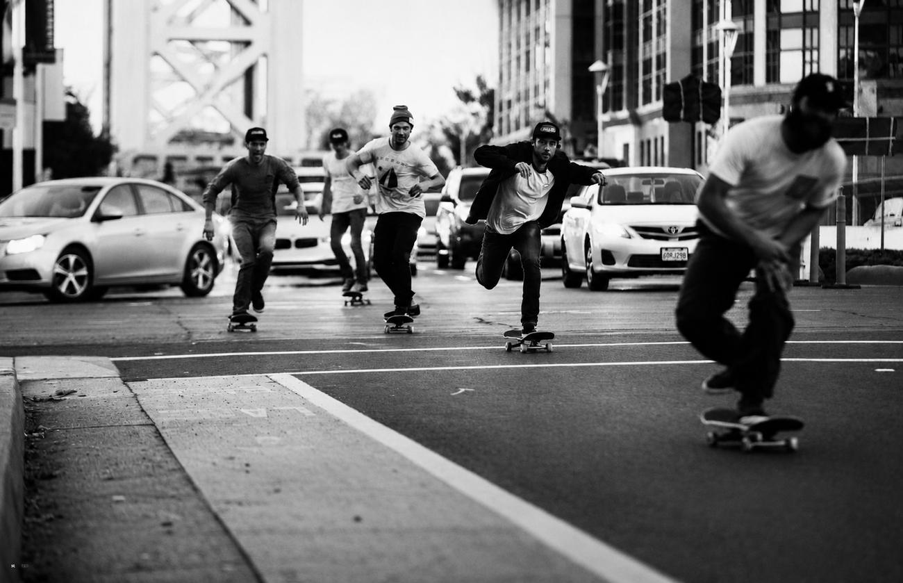 Skateboarders riding through city traffic
